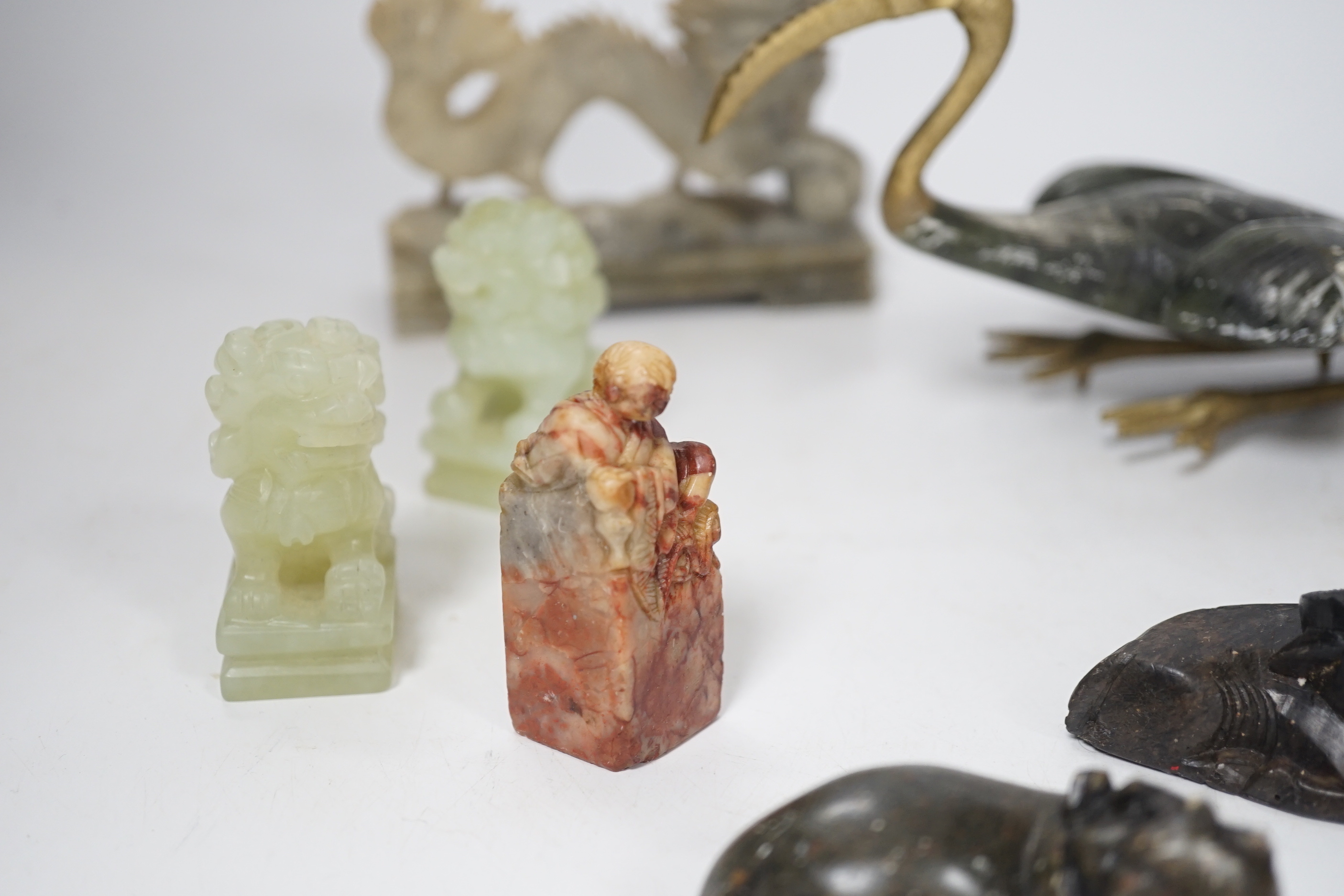 A group of Chinese soapstone and bowenite animal figures and a figural seal, largest 25cm wide (8)